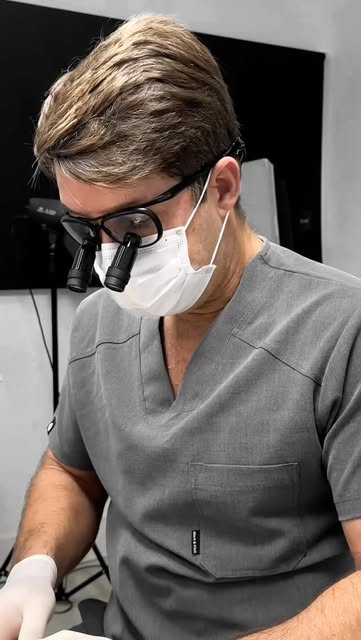 Post do Instagram @clinicahathor mostrando um procedimento odontológico com lupas de precisão